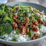A close-up of Sweet and Spicy Turkey Broccoli Bowls featuring glazed turkey, crisp broccoli, and sesame seeds over steamed rice.
