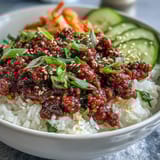 Hearty Korean beef bowl featuring tender seasoned beef, crisp cucumbers, radish, and tangy kimchi for bold flavors.  