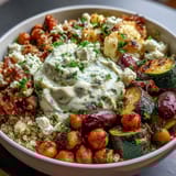 A nourishing vegetarian bowl featuring fluffy quinoa, spiced roasted veggies, and tangy Greek yogurt garnished with fresh parsley and lemon wedges.  