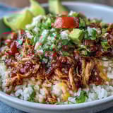 Easy slow cooker salsa chicken served over rice with corn, black beans, and a colorful mix of fresh vegetables.