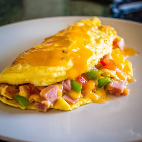 A perfectly cooked Denver Omelet, showcasing diced ham, peppers, and onions, ready to be enjoyed for breakfast.