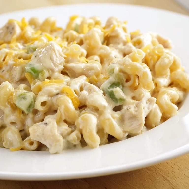 A Southwestern-inspired Green Chili Chicken Mac featuring elbow macaroni coated in a savory, cheese-blend sauce with mild green chiles.
