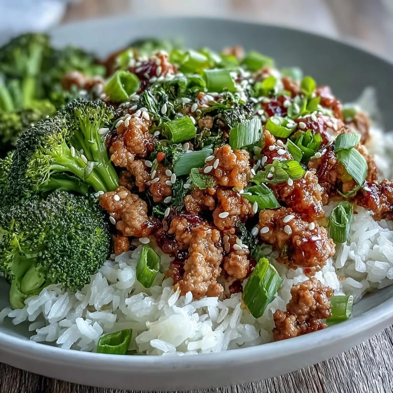 A close-up of Sweet and Spicy Turkey Broccoli Bowls featuring glazed turkey, crisp broccoli, and sesame seeds over steamed rice.