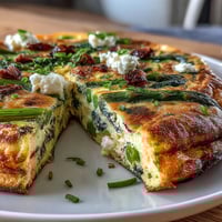 Spring Frittata with Asparagus, Peas and Goat Cheese: golden baked eggs with tender spring vegetables and creamy goat cheese crumbles.